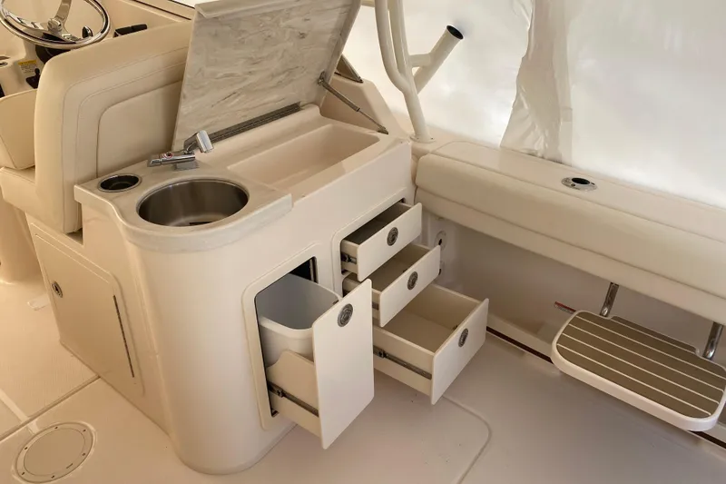 Slide: The Image of 2026 Grady-White Freedom 307 boat interior with sink, storage drawers, and seating. - 13