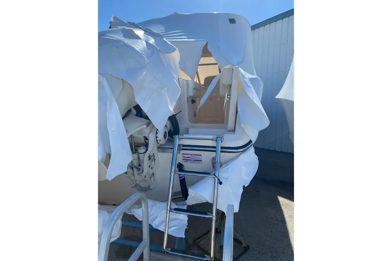 Slide: The Image of 2026 Grady-White Freedom 307 boat partially covered, with ladder and engine visible. - 17