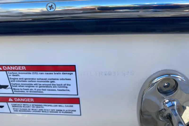 Slide: The Image of 2026 Grady-White Freedom 307 boat with safety warning labels and metal fittings. - 20