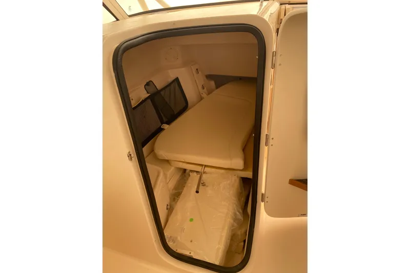 Slide: The Image of 2026 Grady-White Freedom 307 cabin interior with cushioned seating and storage space. - 5