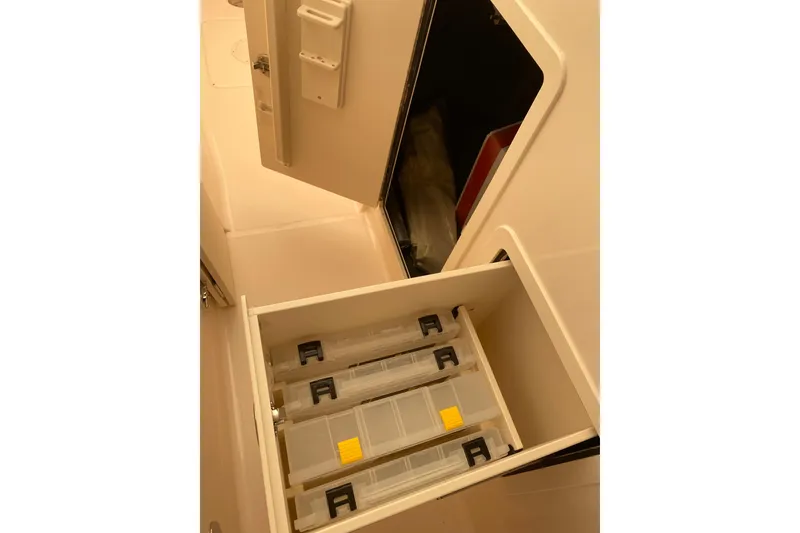Slide: The Image of Storage compartment with organized tackle boxes in a 2026 Grady-White Freedom 307 boat. - 7