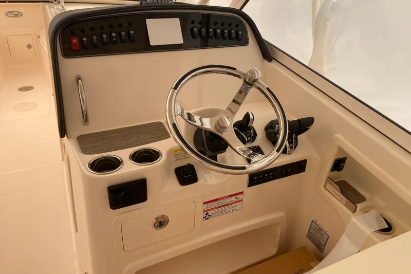 Slide: The Image of 2026 Grady-White Freedom 307 boat helm with steering wheel and control panel. - 9