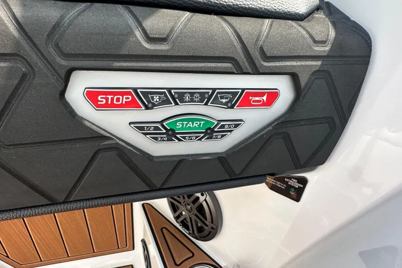 Slide: The Image of Control panel of 2026 Nautique Super Air Nautique GS22E boat with start and stop buttons. - 11