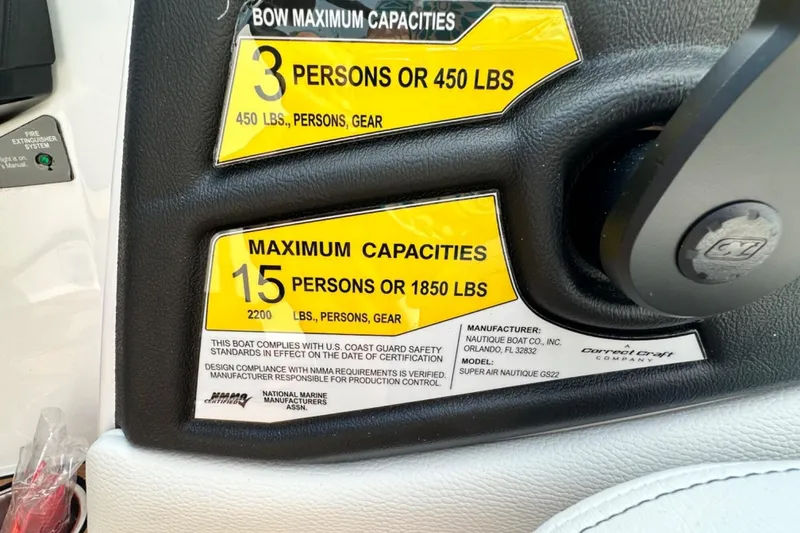 Slide: The Image of Capacity labels on 2026 Nautique Super Air Nautique GS22E, showing person and weight limits. - 13