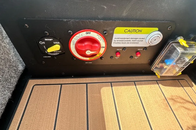 Slide: The Image of Control panel of 2026 Nautique Super Air Nautique GS22E with caution label and switches. - 14