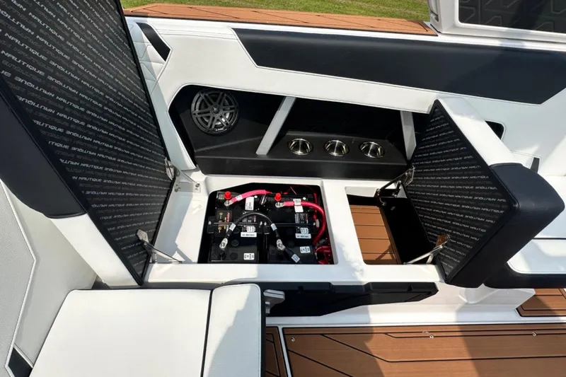 Slide: The Image of 2026 Nautique Super Air Nautique GS22E interior with open battery compartment and speaker. - 15