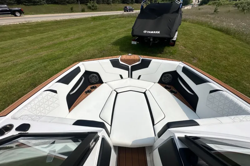 Slide: The Image of 2026 Nautique Super Air Nautique GS22E boat interior with white seating and cup holders. - 17