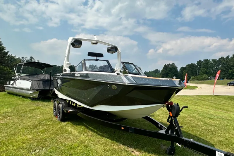 Slide: The Image of 2026 Nautique Super Air Nautique GS22E boat on trailer, displayed outdoors. - 22