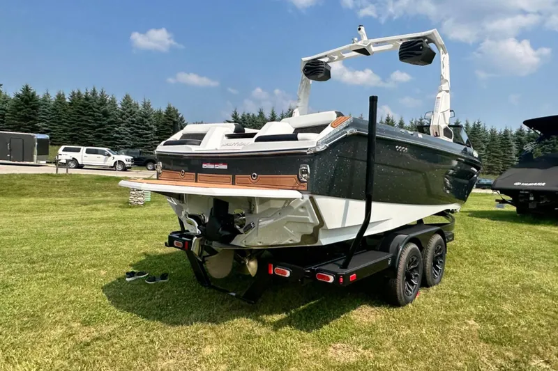 Slide: The Image of 2026 Nautique Super Air Nautique GS22E boat on trailer, parked on grass. - 26