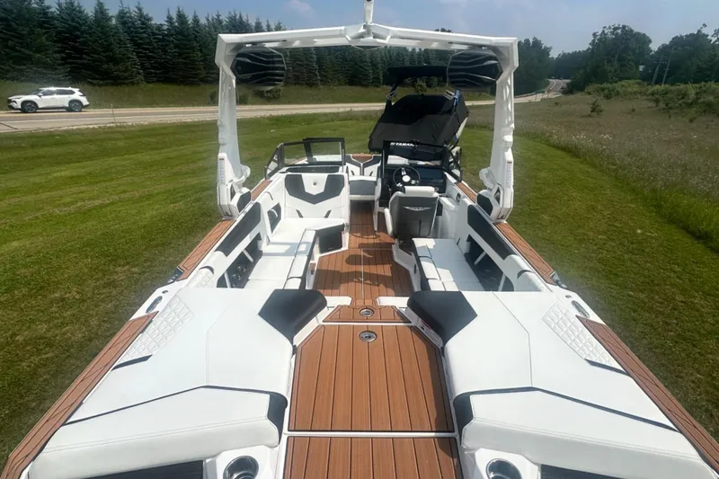 Slide: The Image of 2026 Nautique Super Air Nautique GS22E boat with sleek interior design on grassy landscape. - 3