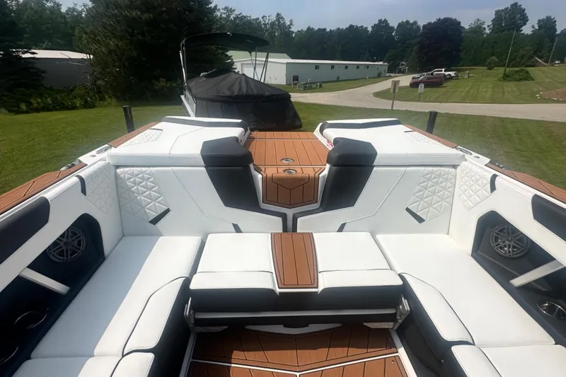 Slide: The Image of 2026 Nautique Super Air Nautique GS22E interior with white and tan seating, outdoor setting. - 5