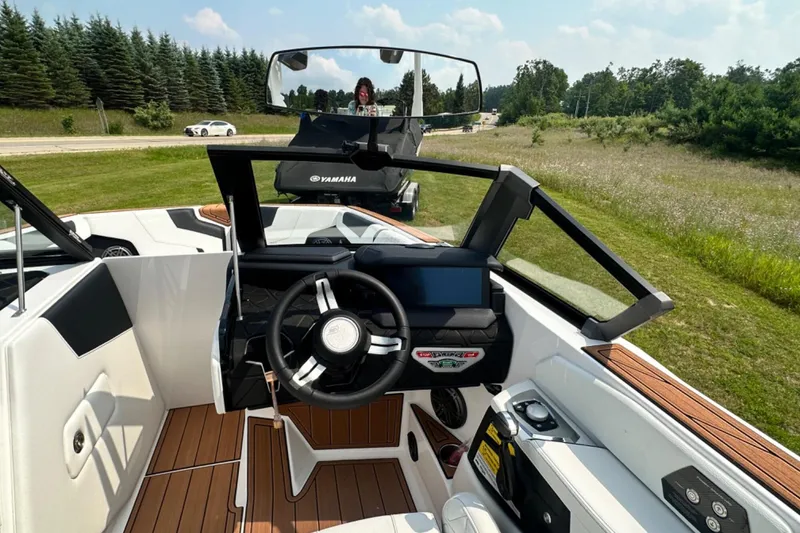 Slide: The Image of 2026 Nautique Super Air Nautique GS22E boat interior with steering wheel and dashboard. - 8
