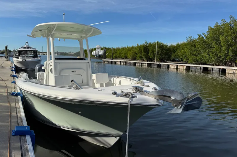 Slide: The Image of 2014 Sea Hunt Gamefish 25 boat docked in a serene marina setting. - 1