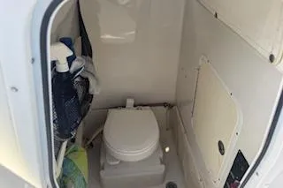 Slide: The Image of 2014 Sea Hunt Gamefish 25 boat interior with compact marine toilet. - 16