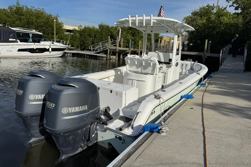 Slide: The Image of 2014 Sea Hunt Gamefish 25 boat docked with twin Yamaha engines. - 2