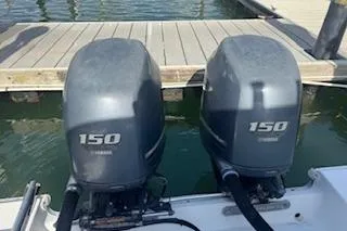 Slide: The Image of Twin Yamaha 150 engines on a 2014 Sea Hunt Gamefish 25 at a dock. - 3