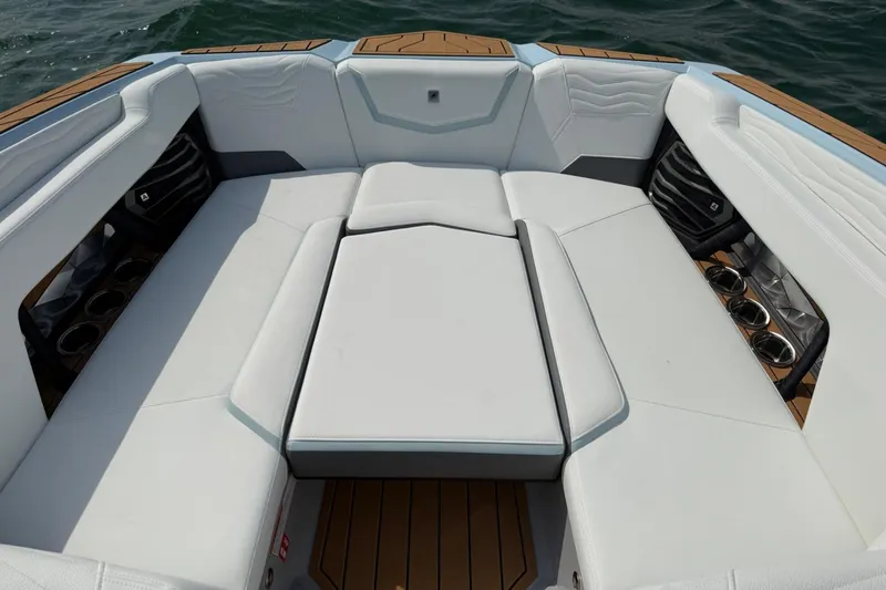 Slide: The Image of 2026 Nautique Super Air Nautique G25 boat interior with white seating and cup holders. - 11