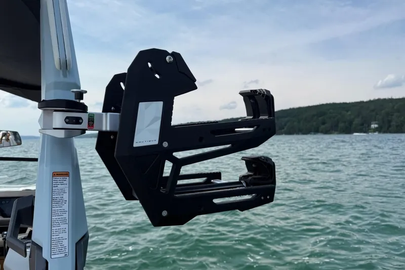 Slide: The Image of 2026 Nautique Super Air Nautique G25 wakeboard rack on a lake. - 16