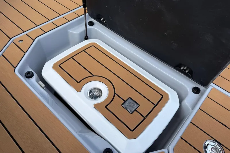 Slide: The Image of 2026 Nautique Super Air Nautique G25 storage compartment with teak-style flooring. - 19