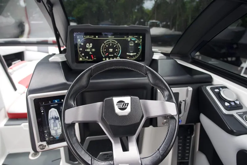 Slide: The Image of 2021 Malibu M220 boat dashboard with steering wheel and digital displays. - 8