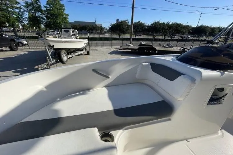 Slide: The Image of 2017 Bayliner Element E16 boat interior with seating and storage, parked outdoors. - 13