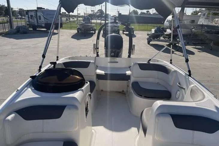 Slide: The Image of 2017 Bayliner Element E16 boat interior with seating and canopy in a marina setting. - 5