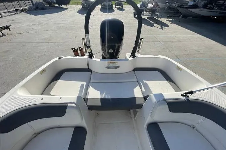 Slide: The Image of 2017 Bayliner Element E16 boat interior with seating and motor, parked on concrete. - 9