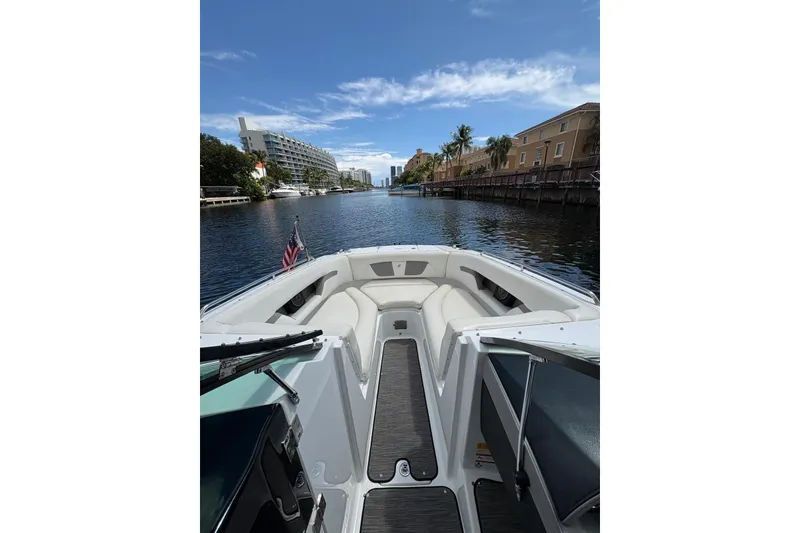 Slide: The Image of 2020 Four Winns HD240 OB boat cruising on a scenic waterway with clear skies. - 16