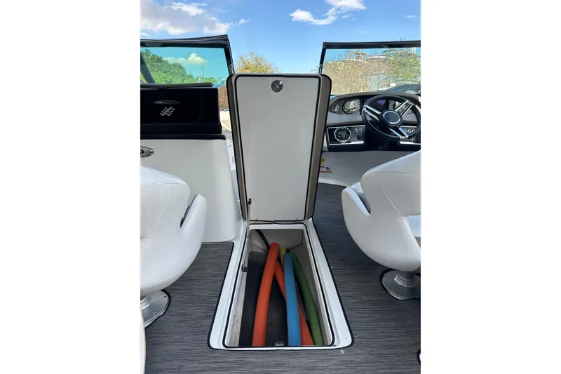 Slide: The Image of 2020 Four Winns HD240 OB boat interior with open storage compartment and colorful pool noodles. - 37