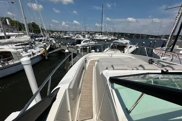 Slide: The Image of 2021 Sea Ray Sundancer 320 docked at a marina with sailboats in the background. - 6
