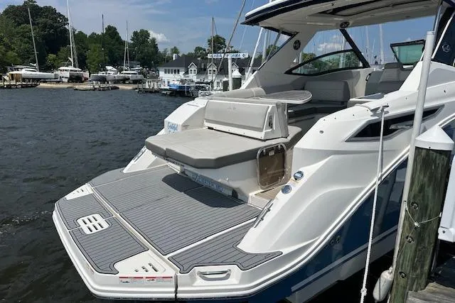 Slide: The Image of 2021 Sea Ray Sundancer 320 yacht docked at marina, showcasing spacious deck and seating area. - 8