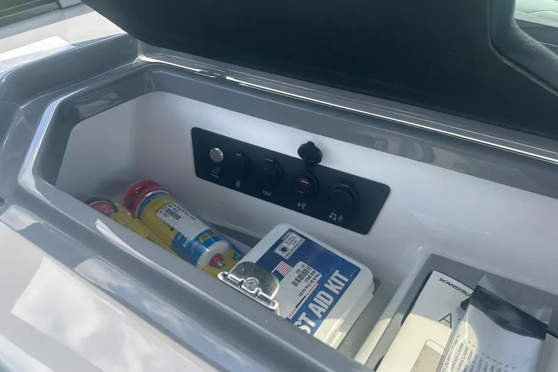 Slide: The Image of Storage compartment in 2026 Nautique Super Air Nautique G23 with first aid kit and accessories. - 23