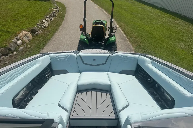 Slide: The Image of 2026 Nautique Super Air Nautique G23 boat interior with light blue seating and cup holders. - 29