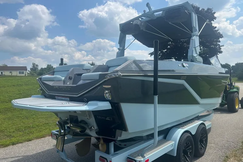 Slide: The Image of 2026 Nautique Super Air Nautique G23 boat on trailer, parked outdoors under cloudy sky. - 6