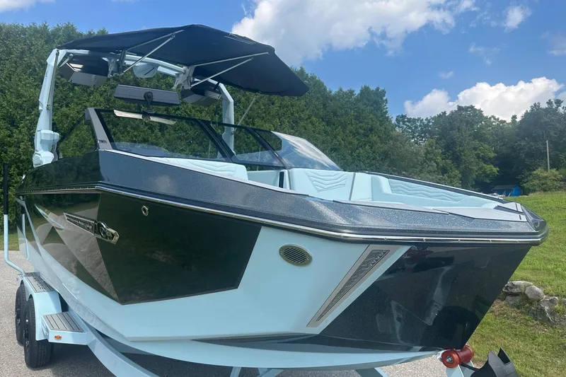 Slide: The Image of 2026 Nautique Super Air Nautique G23 boat with canopy, parked on trailer. - 8