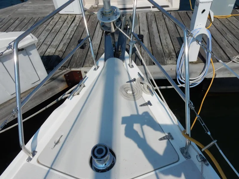 Slide: The Image of Bow of a 2004 Catalina 350 sailboat docked, featuring deck hardware and railing. - 11