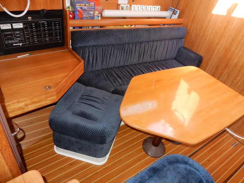 Slide: The Image of Interior of 2004 Catalina 350 sailboat with wooden table and blue upholstered seating. - 20