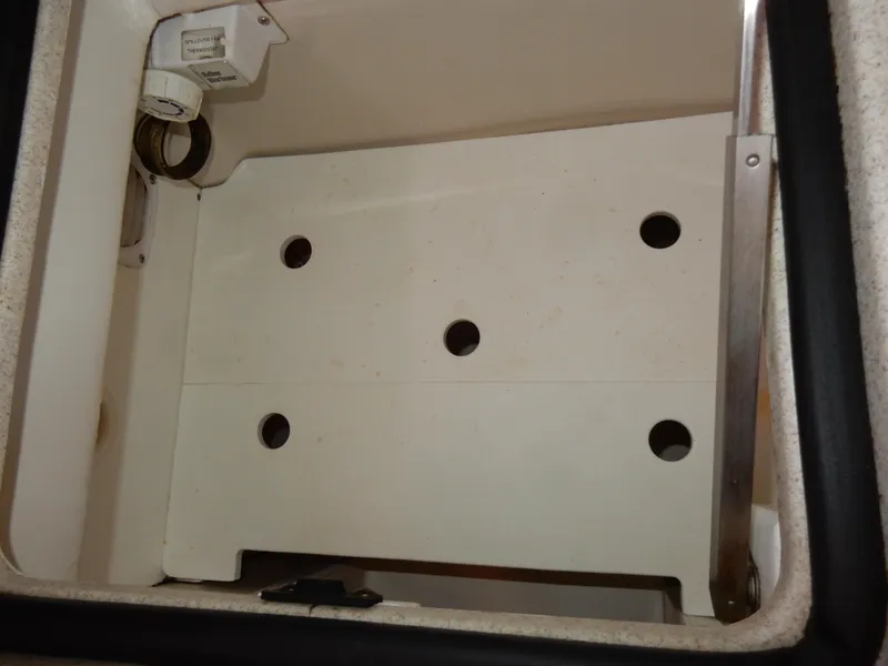 Slide: The Image of Storage compartment in a 2004 Catalina 350 sailboat, featuring multiple circular cutouts. - 26