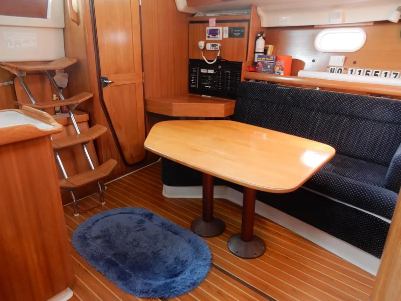 Slide: The Image of Interior of 2004 Catalina 350 sailboat with wooden table and seating area. - 31