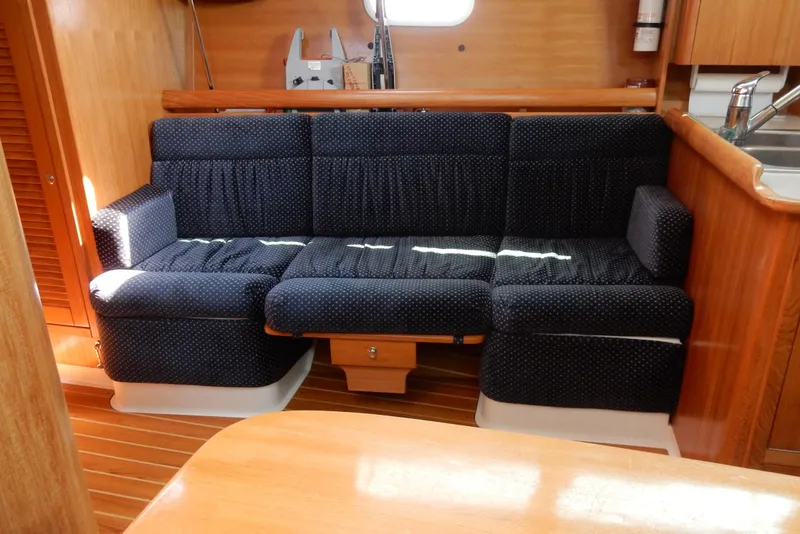 Slide: The Image of Interior of 2004 Catalina 350 yacht with blue upholstered seating and wooden finishes. - 33