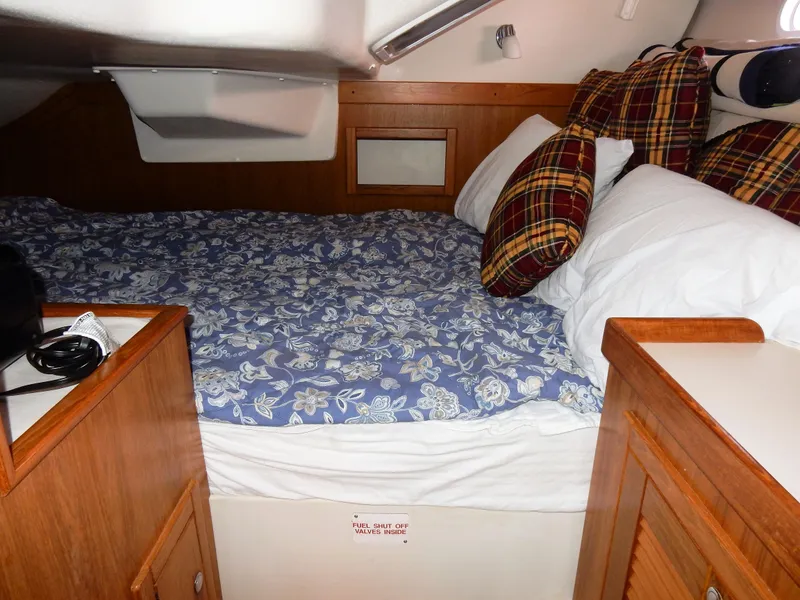 Slide: The Image of Cozy cabin interior of a 2004 Catalina 350 sailboat with floral bedding and plaid pillows. - 34