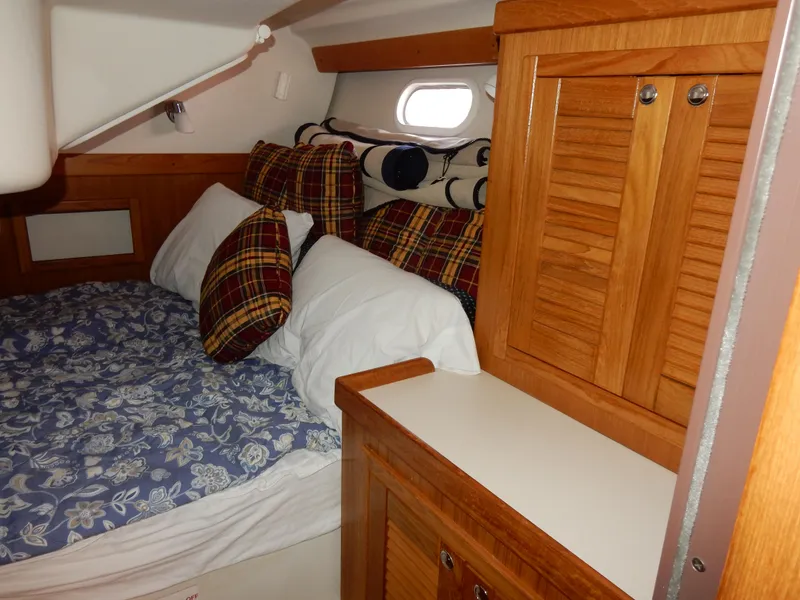 Slide: The Image of Cozy cabin interior of 2004 Catalina 350 sailboat with plaid pillows and wooden cabinetry. - 35