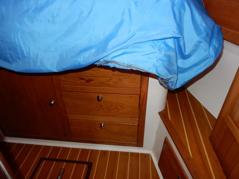 Slide: The Image of Interior cabin of 2004 Catalina 350 sailboat with wooden drawers and blue bedding. - 37