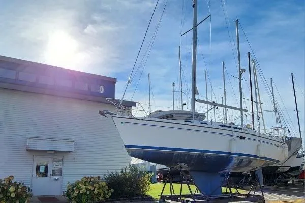 Slide: The Image of 2004 Catalina 350 sailboat on display outside a building under a clear blue sky. - 80