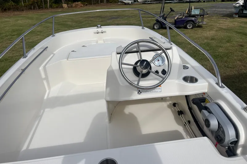 Slide: The Image of 2026 Boston Whaler 130 Super Sport boat interior with steering wheel and controls. - 10