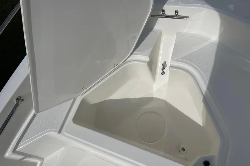 Slide: The Image of 2026 Boston Whaler 130 Super Sport storage compartment, open lid, white interior. - 6