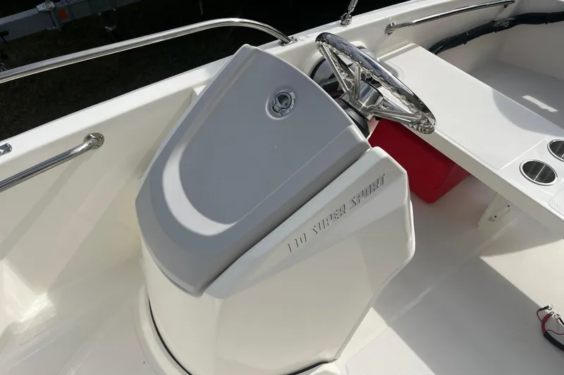 Slide: The Image of 2026 Boston Whaler 130 Super Sport boat interior with steering wheel and console. - 7