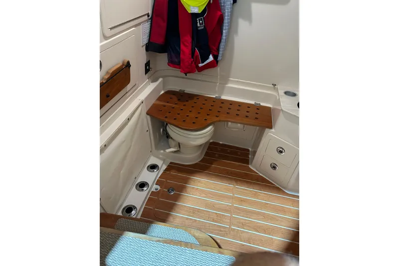Slide: The Image of 2019 Grady-White Canyon 336 boat interior with wooden flooring and compact bathroom. - 11