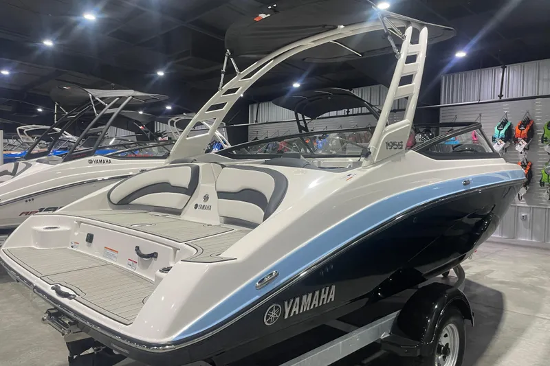Slide: The Image of 2025 Yamaha Boats 195S on display in a showroom, featuring sleek design and modern amenities. - 2