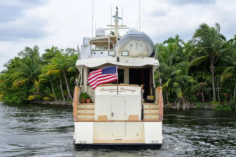Slide: The Image of 1991 Hatteras 78 CMY yacht cruising on a tropical waterway with American flag. - 10